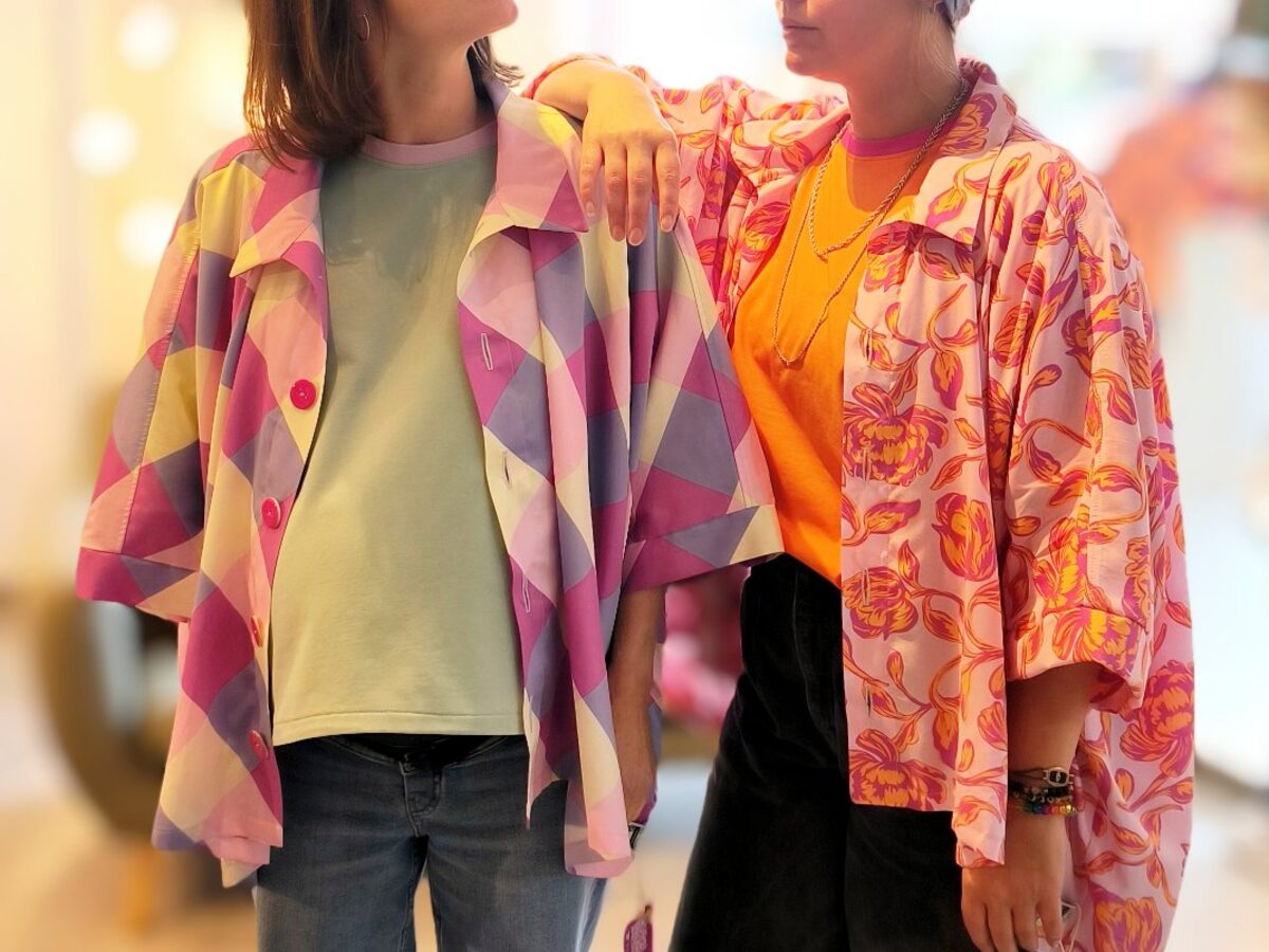 Deux clientes souriantes en t-shirts CR dans la boutique de Mettet